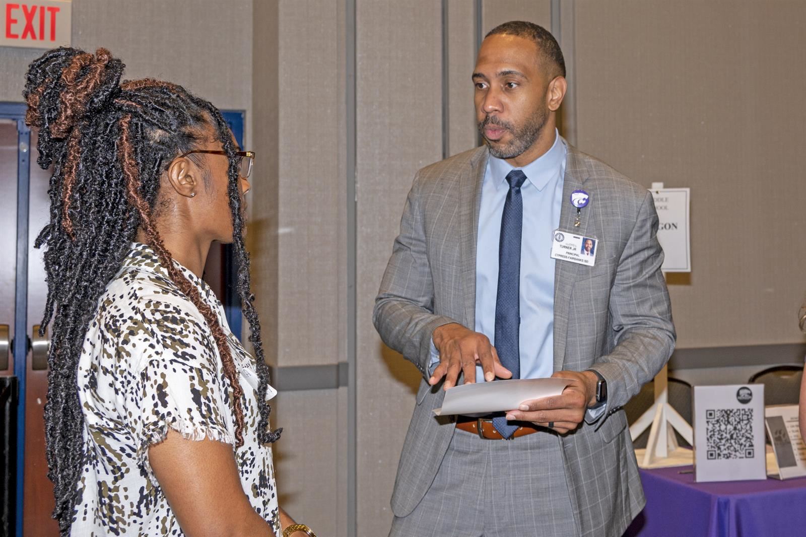 Lloyd Turner, the principal at Aragon Middle School, speaks with a guest at the CFISD Career Fair in April 2022.